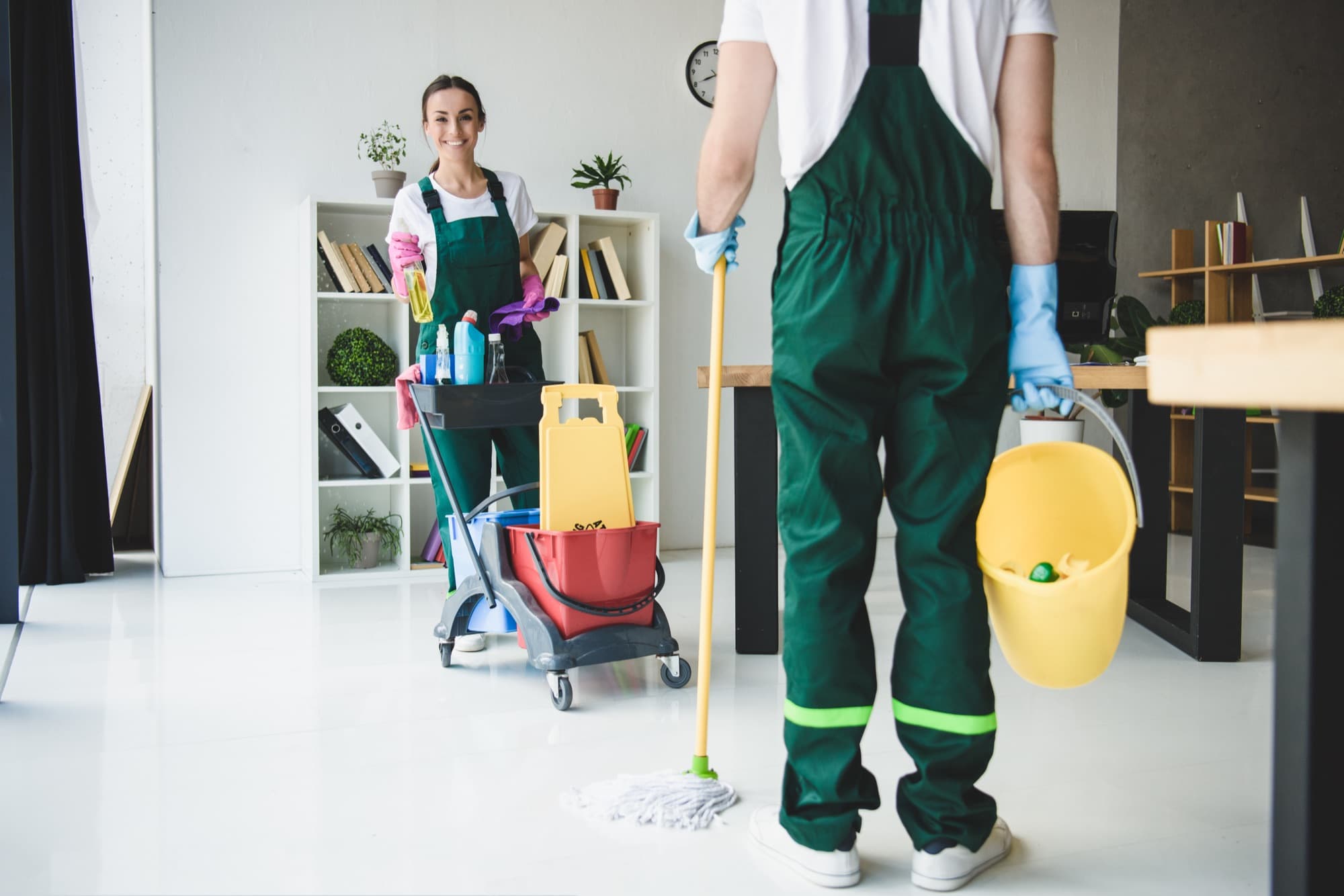 Two Pando Cleaning Solutions team members with cleaning supplies in a bright, freshly cleaned home